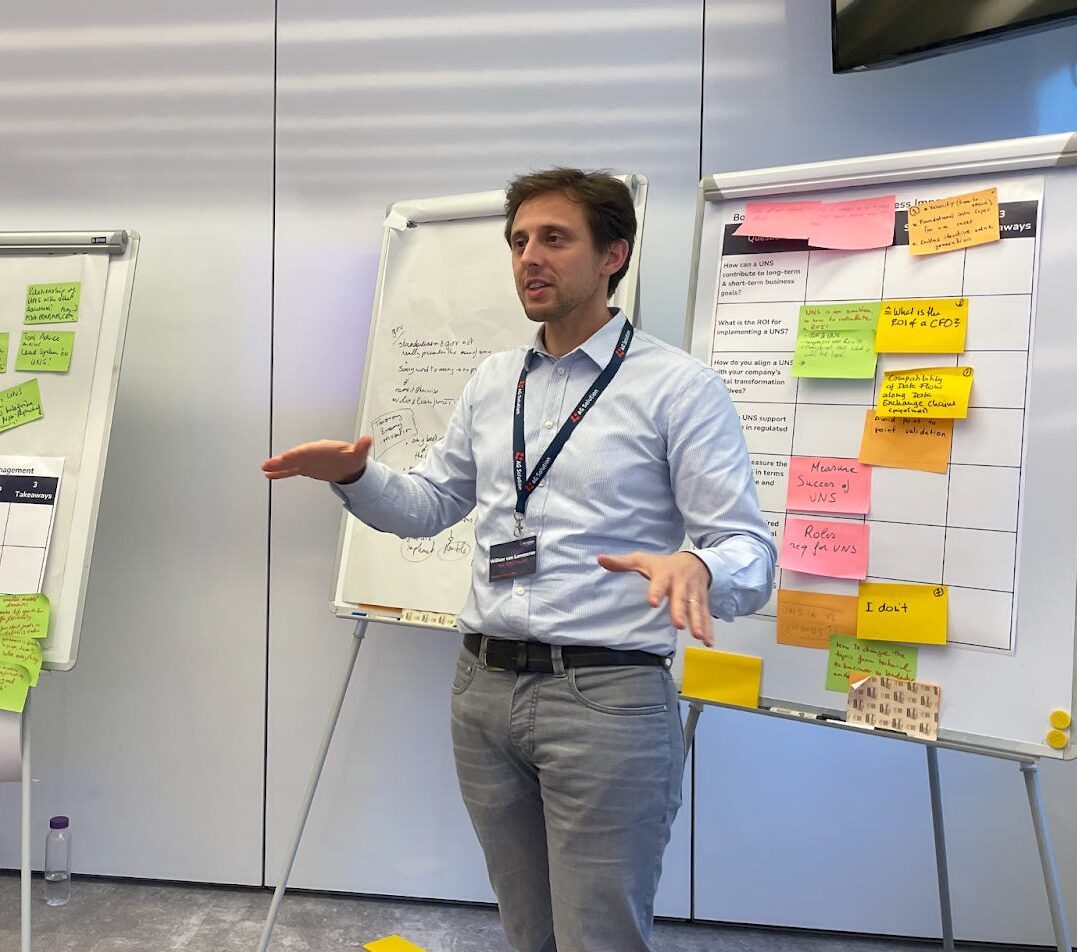 Willem presenting in front of flipcharts covered in sticky notes.